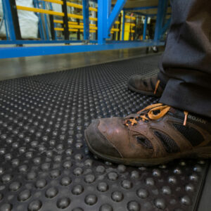 Man standing on Bubbled Detailed Anti-Fatigue Interlocking Tiles