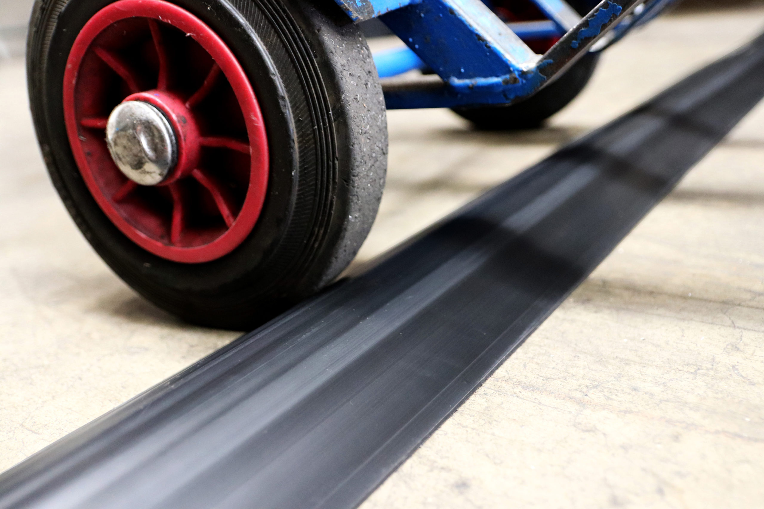 Close up of wheeled object going over a heavy duty cable protector