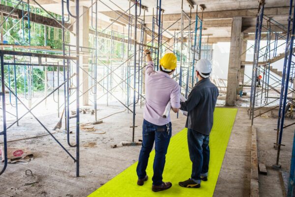 Builders stood on high visibility path at construction site