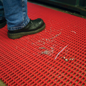 Man standing on a red Medium Duty Woven PVC Mat