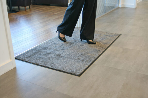 Woman walking on a beige microfibre washable doormat in high heels