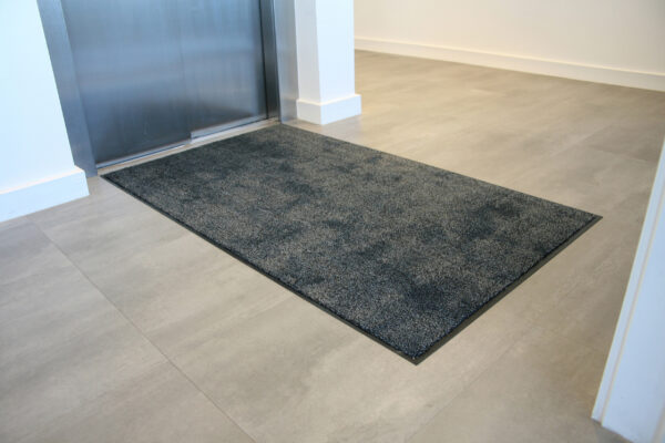 Black microfibre washable doormat outside an elevator