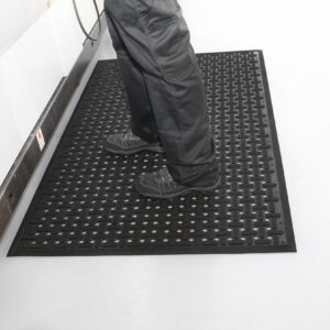 Person standing on black Rubber Anti-Fatigue mat with X detailing